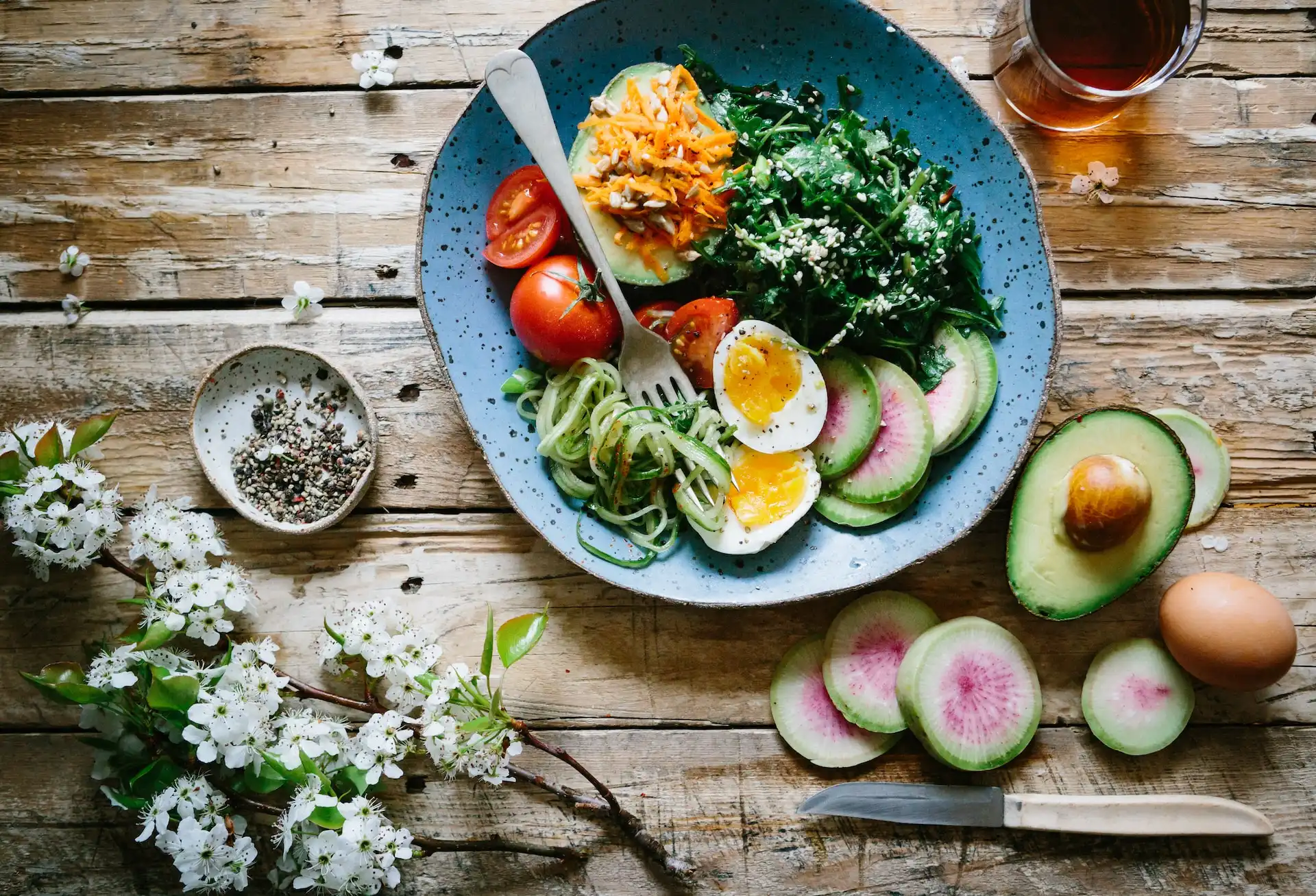 A plate of healthy food with egg, fruits, and vegetables