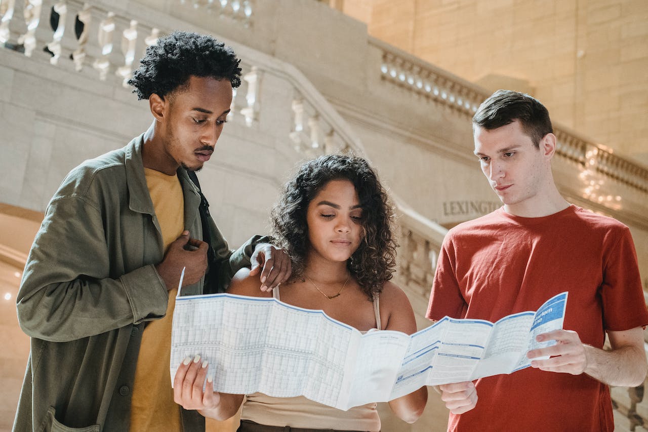Two men and one girl looking at a catalog