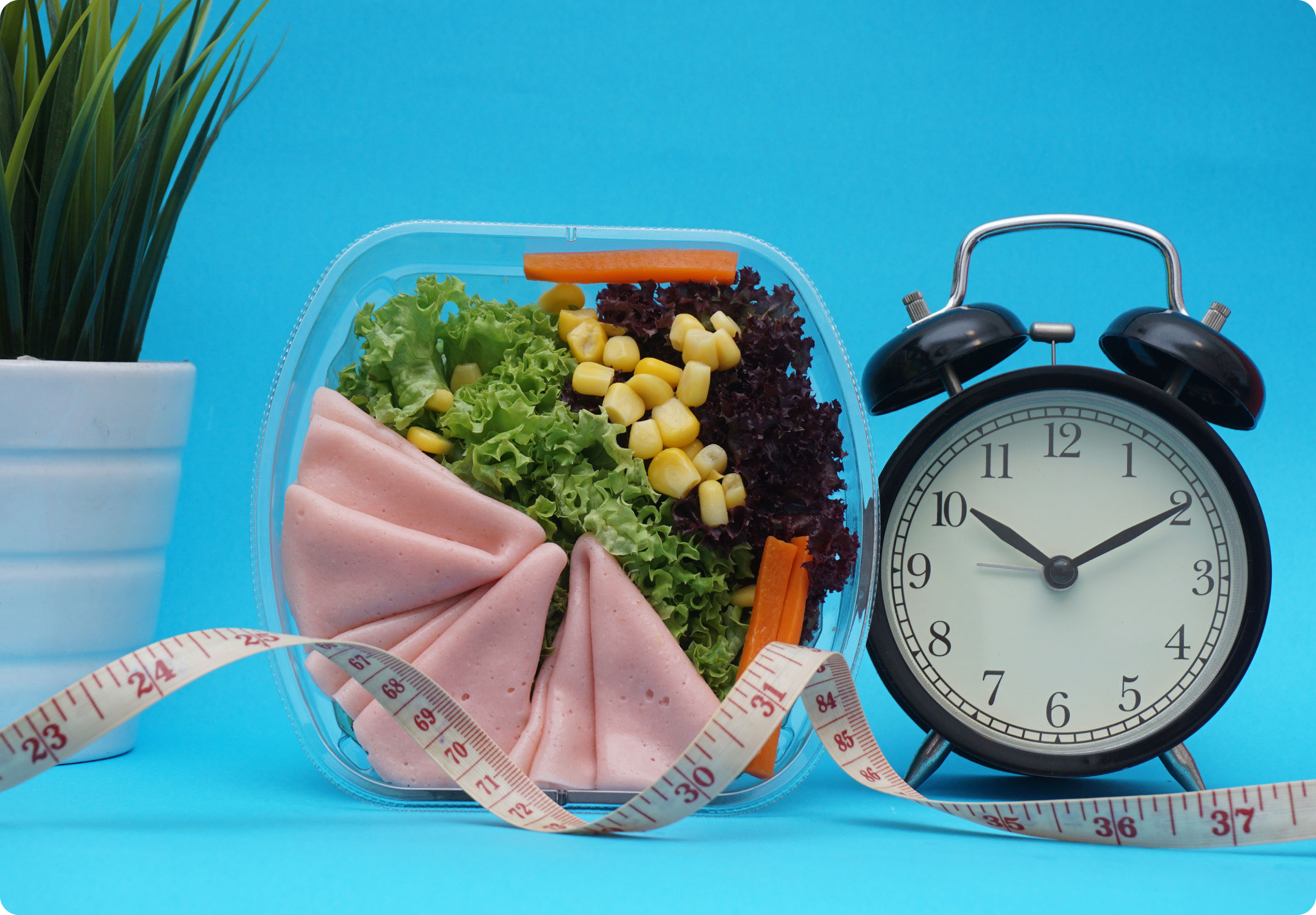 A bowl full of vegetable, meat, and fruits with clock and measuring tape